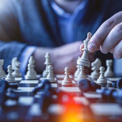 Hand moving chess pieces on a chess board